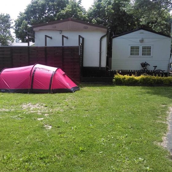 Camping Ibaia en Vitoria-Gasteiz con tienda de campaña roja junto a bungalows