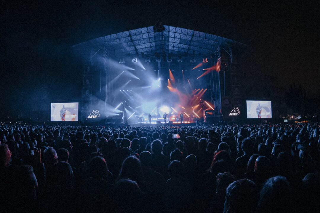 Escenario principal del Azkena Rock Festival de noche con luces azules y rojas ante un público multitudinario.