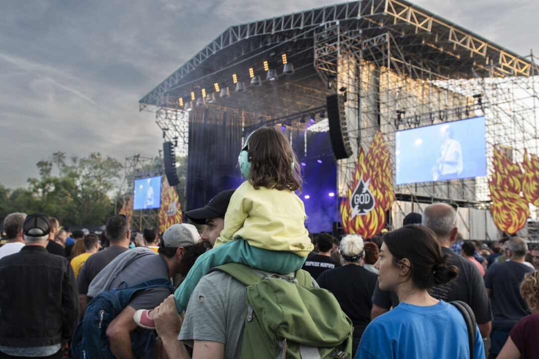 Menor con protectores auditivos sobre los hombros de su padre disfrutando de un concierto en el Azkena Rock Festival.